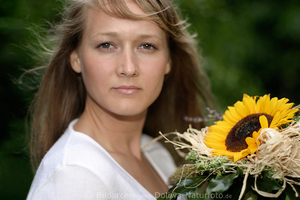 Girl blond in wind with bouquet sunflowers