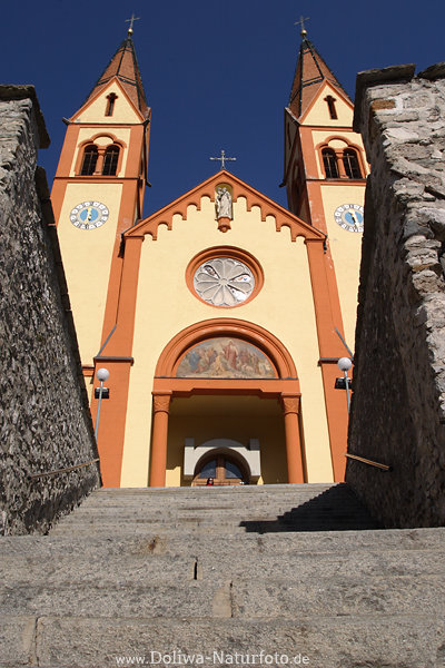 Zweiturmkirche Telfs Treppe Eingangstor gelbbraun Fassade am Himmel